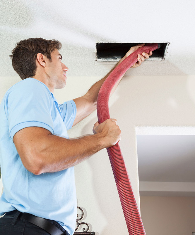 A technician cleaning air ducts